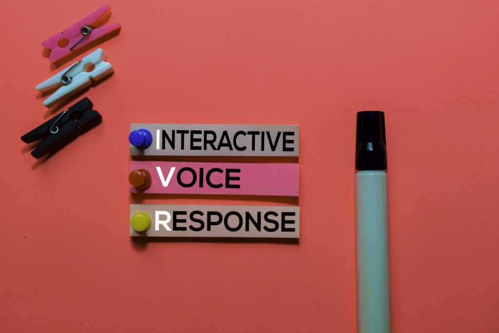 Three strips of paper with the words "Interactive," "Voice," and "Response" written on them, pinned to a red background.