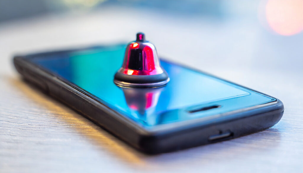 This icon represents an app notification related to AI-powered SMS marketing. The red bell symbolizes an alert or notification, while the smartphone indicates the device receiving the message