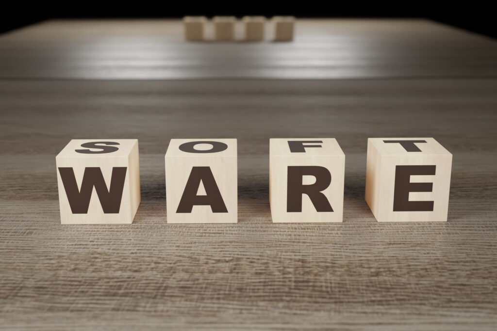 Wooden blocks spelling out the word "SOFTWARE" on a table.