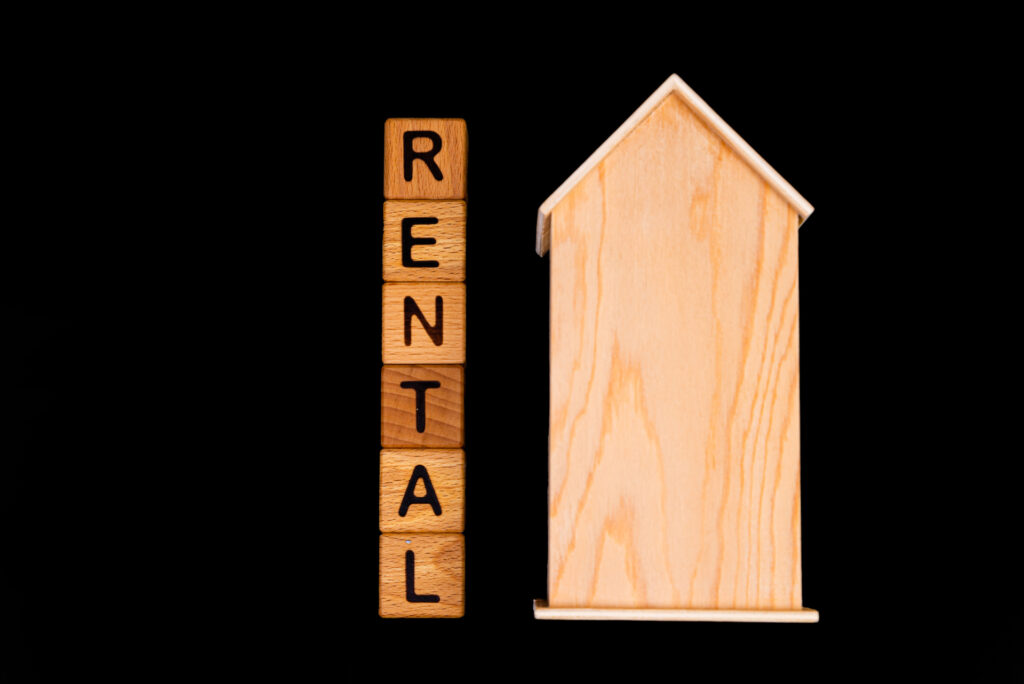 A symbolic image of a rental property, with blocks spelling "RENTAL" and a small wooden house