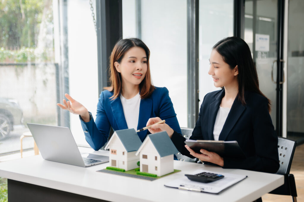 Two women, likely real estate professionals, discussing property details. 