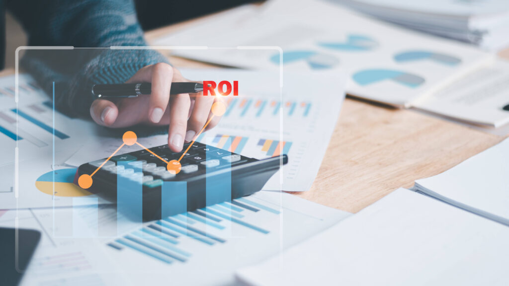 A woman using a calculator to analyze financial data, with the word 'ROI' highlighted, representing the return on investment of software.