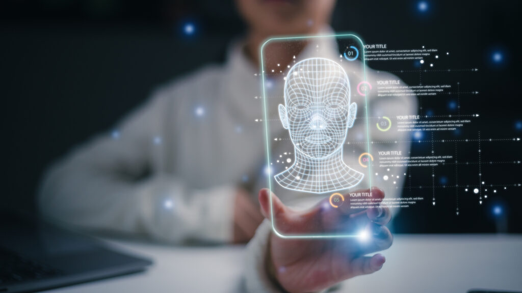 Futuristic holographic display showing wireframe 3D model of a human head, with data points and analytics overlaid. The image suggests advanced software trends in AI, facial recognition, biometrics, and data visualization.