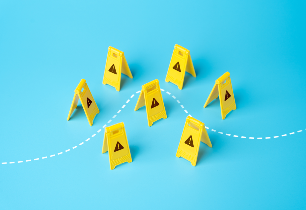 Image depicting risk assessment with seven yellow caution signs arranged on a blue background, connected by a dashed line, symbolizing the identification and management of potential hazards.