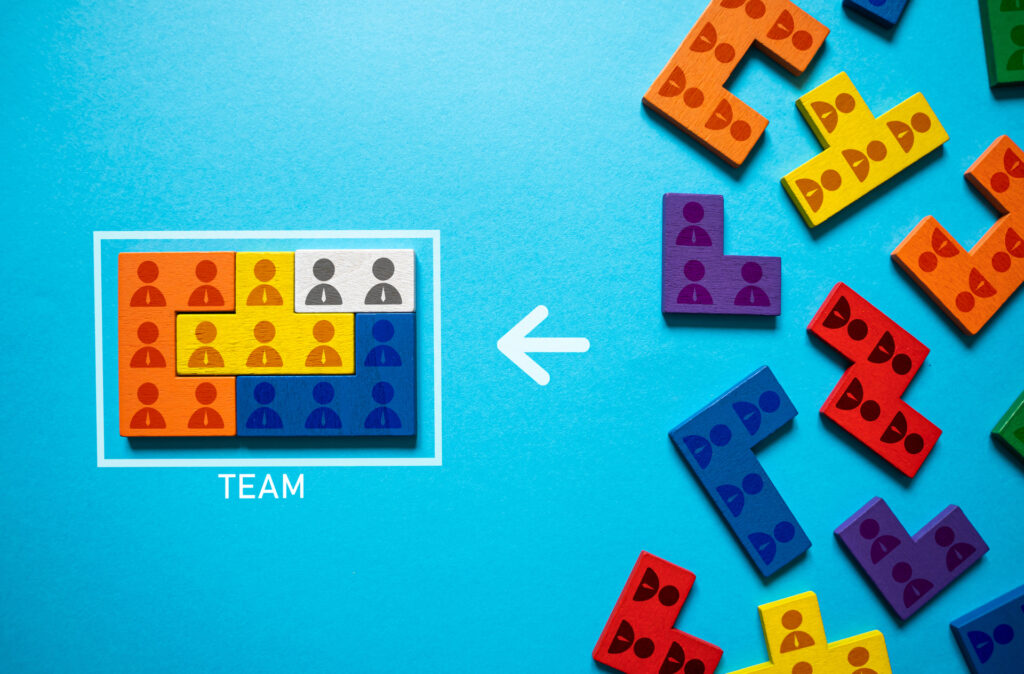 Colorful puzzle pieces with figures representing diverse team members come together within a framed "Team" area, symbolizing the collaborative effort in product discovery.