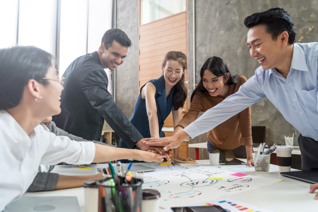 A team of professionals collaborates on a software project, engaging in a project discovery session. They are gathered around a table with diagrams and notes, symbolizing teamwork and brainstorming.