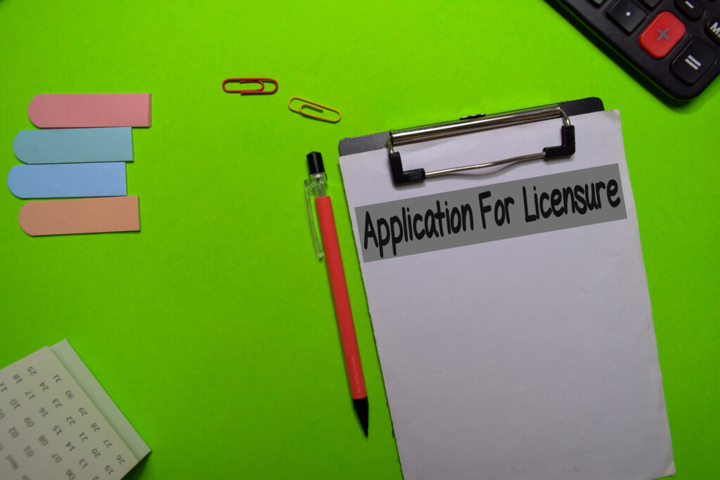 An "Application for Licensure" form on a clipboard, ready to be filled out. Essential paperwork for software licensing.