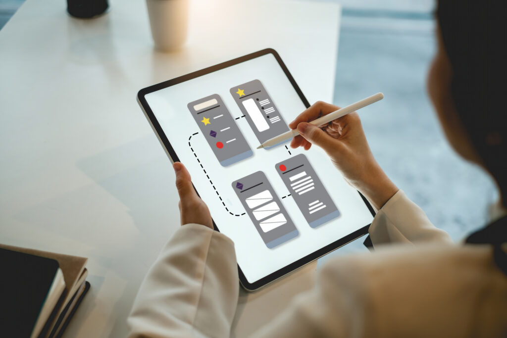 A UI/UX designer working on a tablet, sketching out the user interface for a SaaS app, emphasizing the importance of user experience in SaaS development.