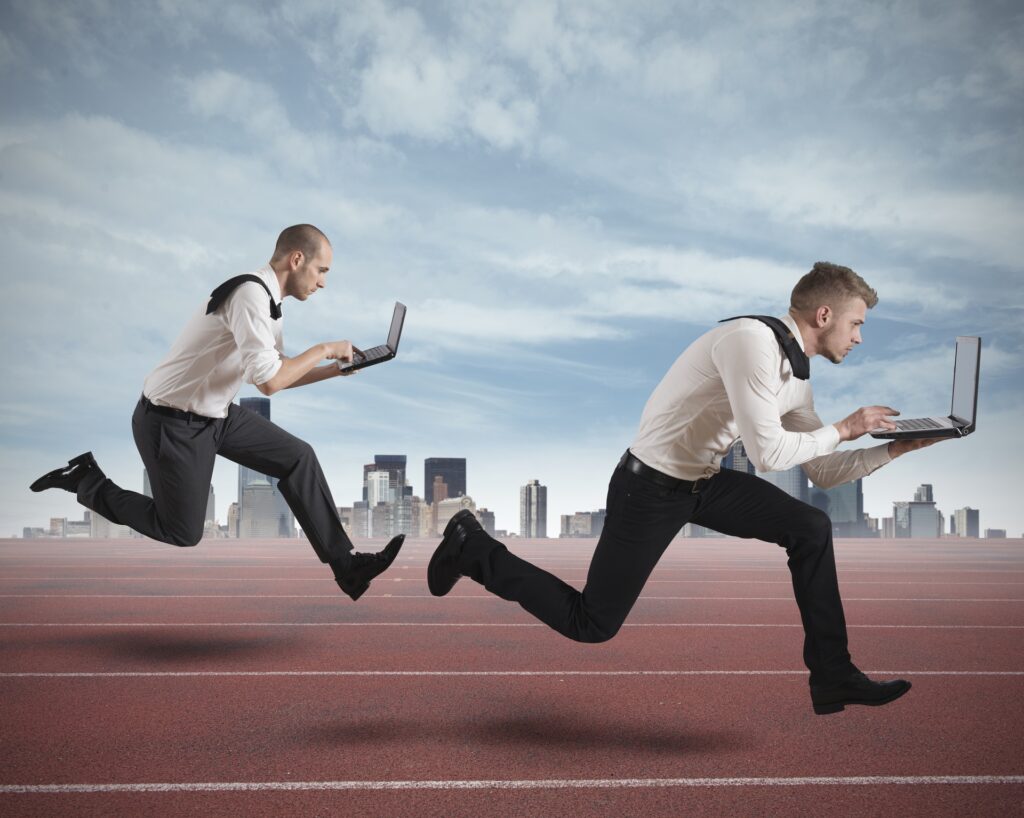 Two businessmen in a race, each holding a laptop, symbolize the competitive advantage web apps can provide over traditional websites. The dynamic image highlights speed, agility, and efficiency, key benefits of web apps in a fast-paced digital landscape.