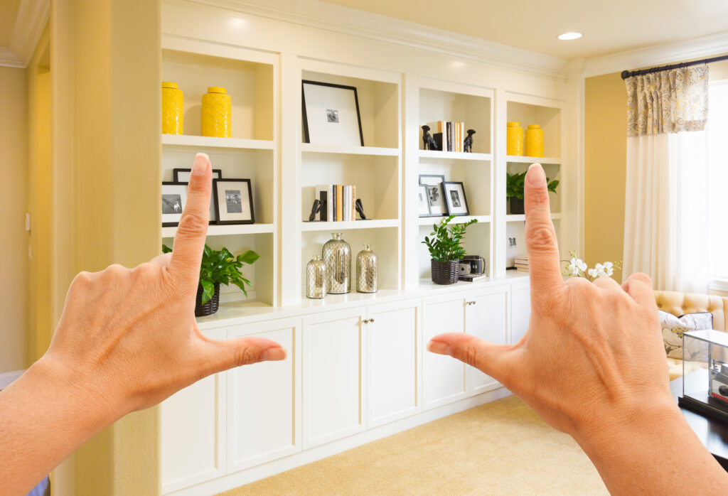 Hands framing a custom built-in shelving unit. This symbolizes the tailored fit of custom automation tools for real estate businesses.