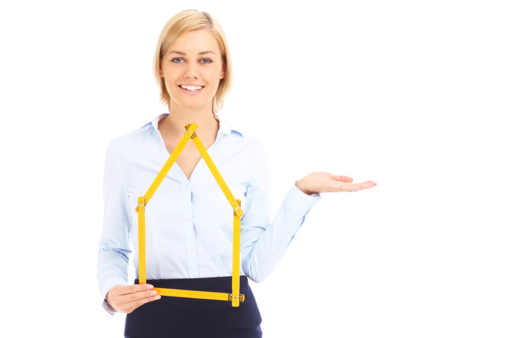 The image shows a young woman wearing a white shirt with a yellow measurement tape around her torso, suggesting she may work in a field related to fashion, design, or tailoring. She is smiling at the camera with an arm outstretched in a welcoming gesture. The background is plain white, keeping the focus on the woman.