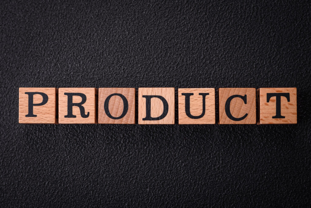 Wooden blocks spelling "PRODUCT" on a dark background, symbolizing the core element of Product Discovery Frameworks.