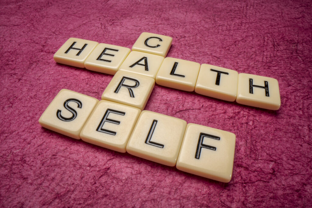 A crossword puzzle of "HEALTHCARE" and "SELF" made with Scrabble tiles, symbolizing the connection between self-care and healthcare.