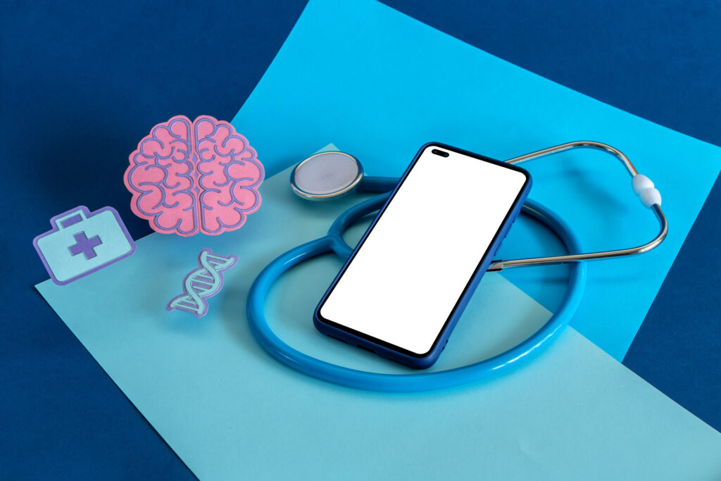 A smartphone with a blank screen rests on a stethoscope, accompanied by a brain, DNA strand, and first aid kit. It represents a healthcare chatbot to fight depression