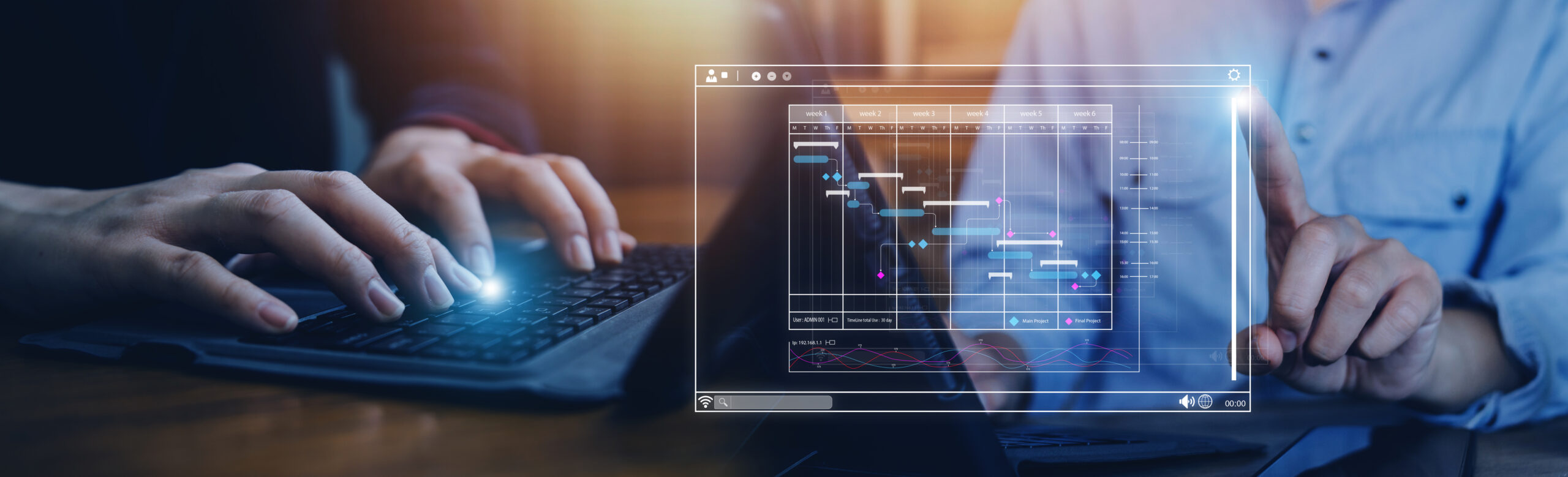 Two people are working on a project together. One person is typing on a laptop, while the other is pointing at a digital Gantt chart displayed on a tablet. The chart outlines the project timeline and tasks.