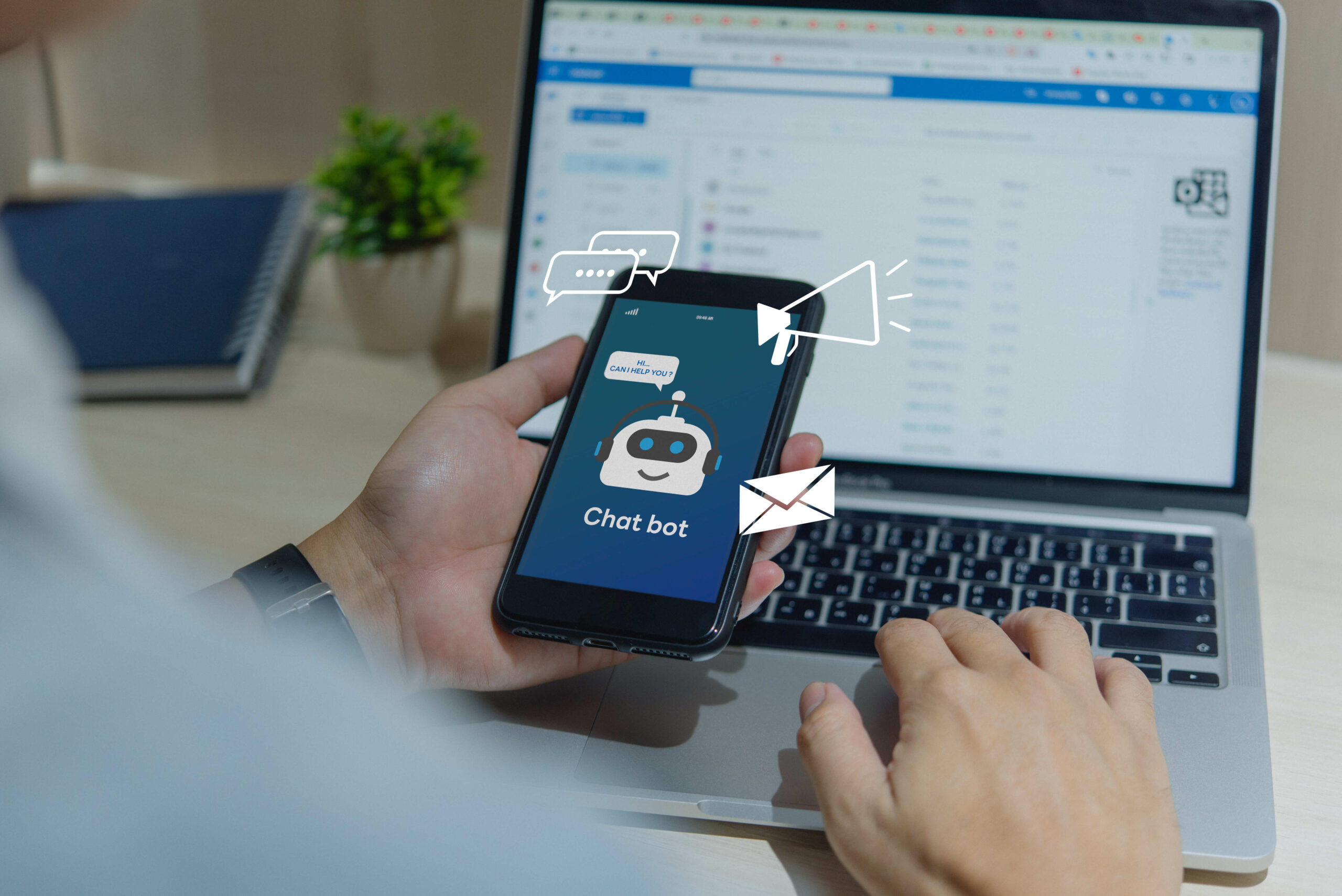 A person uses a chatbot on their smartphone to automate digital marketing tasks, while working on a laptop.