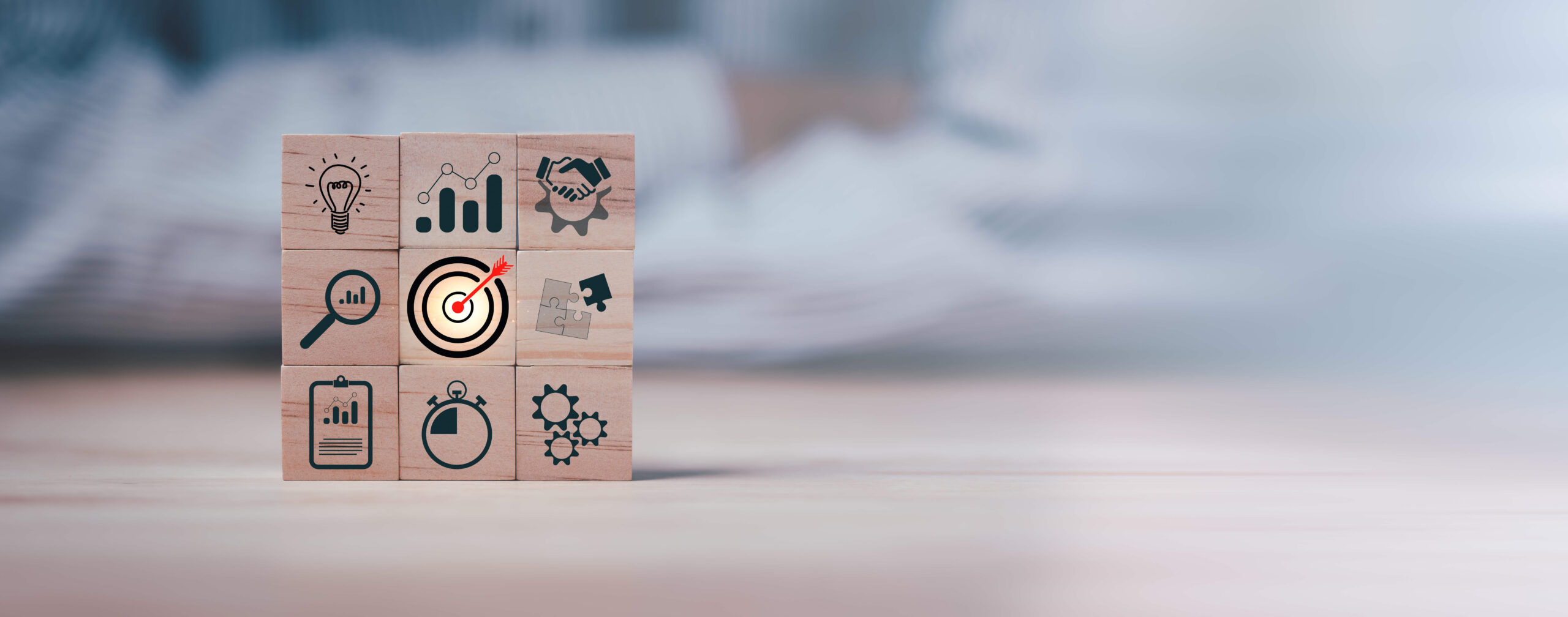 Wooden blocks with various symbols representing growth marketing strategies, including a lightbulb for ideas, a handshake for collaboration, gears for process, a magnifying glass for research, a target for goals, an arrow for direction, a clipboard for planning, a stopwatch for time management, and a gear for efficiency.