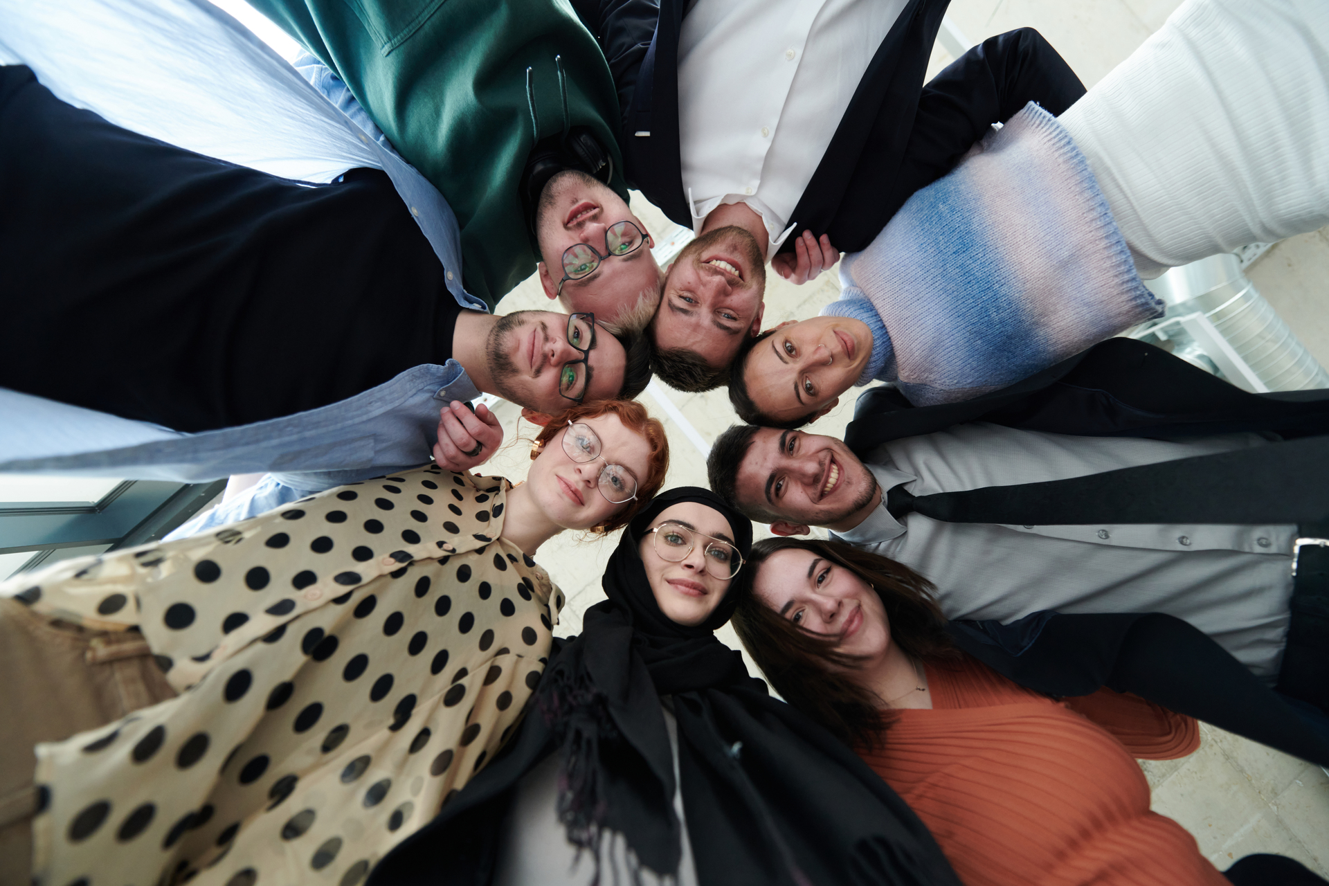 A diverse group of parents and children, hands joined in a circle. The image emphasizes community and support, aligning with the 'Parent App.'